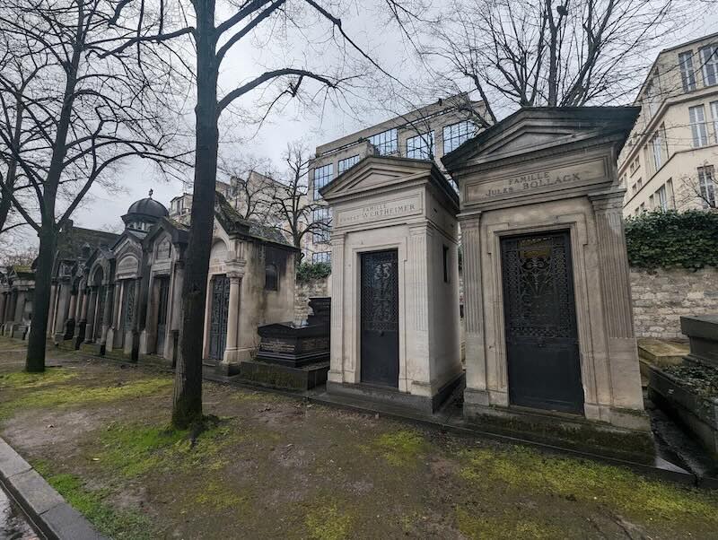 Graveyard of the Montparnasse cemetery with mausoleum structures in the rain