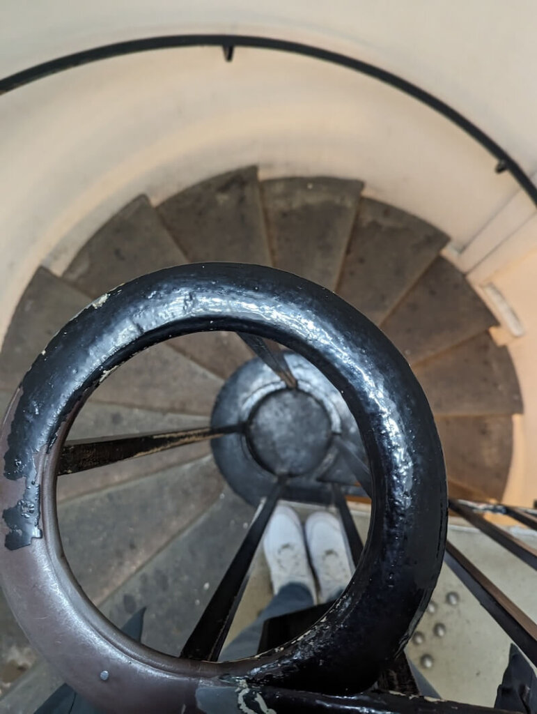 The spiral staircase that leads down to the lower layer where you'll see the spooky catacombs of Paris