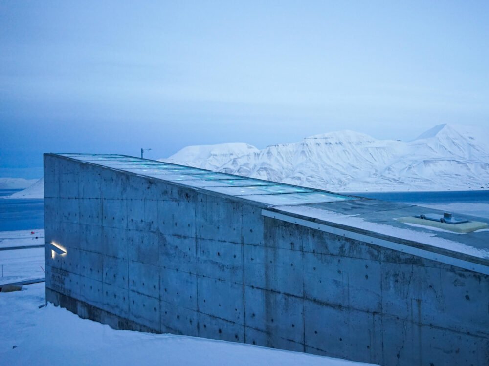 The cool structure of the Svalbard global seed vault with the fjord views behind it