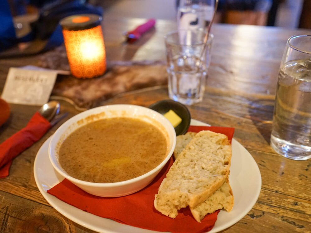 A bowl of mushroom soup and bread served at Kroa with water
