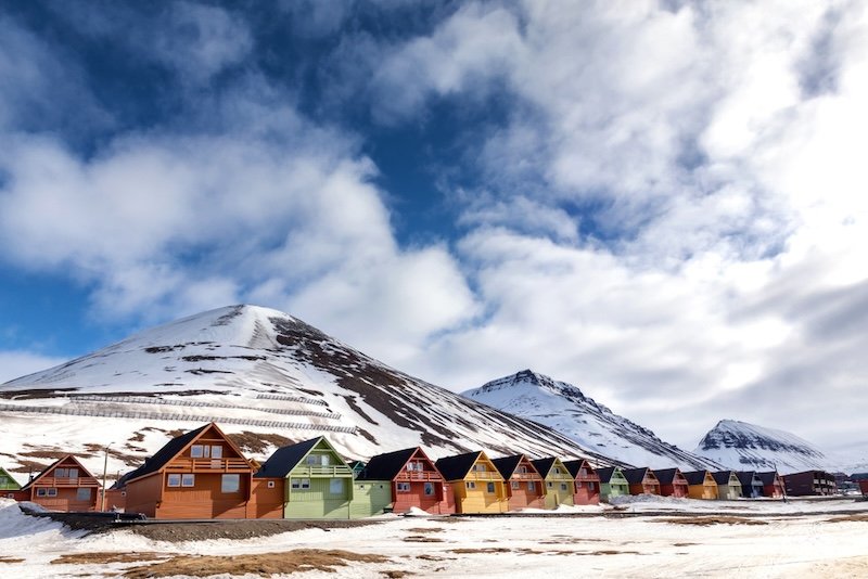 Some streaky snow remains in the downtown area of Longyearbyen with its famous colorful painted houses with the sun quite high in the sky in the middle of the midnight sun