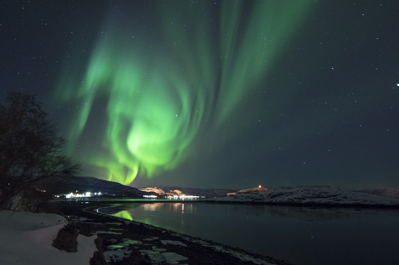 View of the Northern lights over a fjord in alta norway