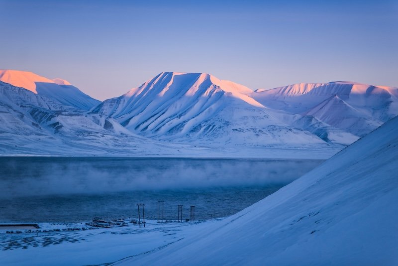 Winter mountain nature Svalbard Longyearbyen Svalbard Norway with blue sky and snowy peaks on a sunny day wallpaper during sunset sunrise orange fire