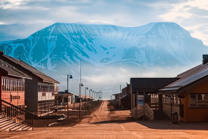 Summer view of the main street of Longyearbyen town, with nobody out and about, and the tall mountain looming over the town