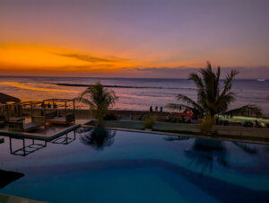 sunset at a hotel with an infinity pool pacing the ocean in kupang indonesia