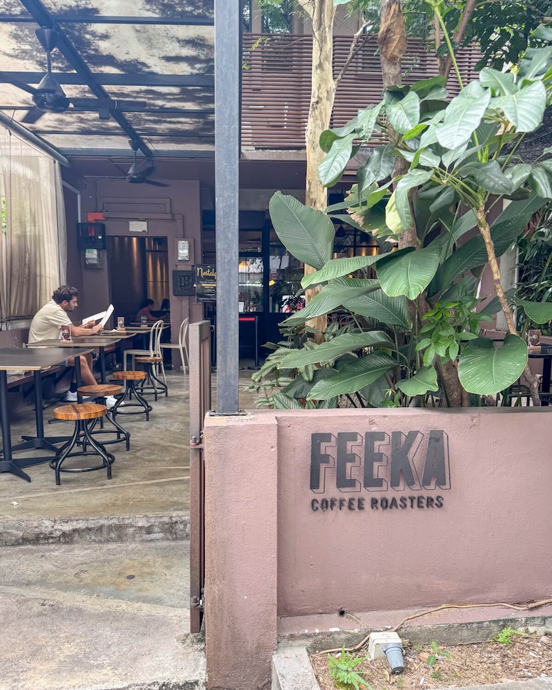 Exterior of coffee shop called Feeka with foliage and seating outdoors