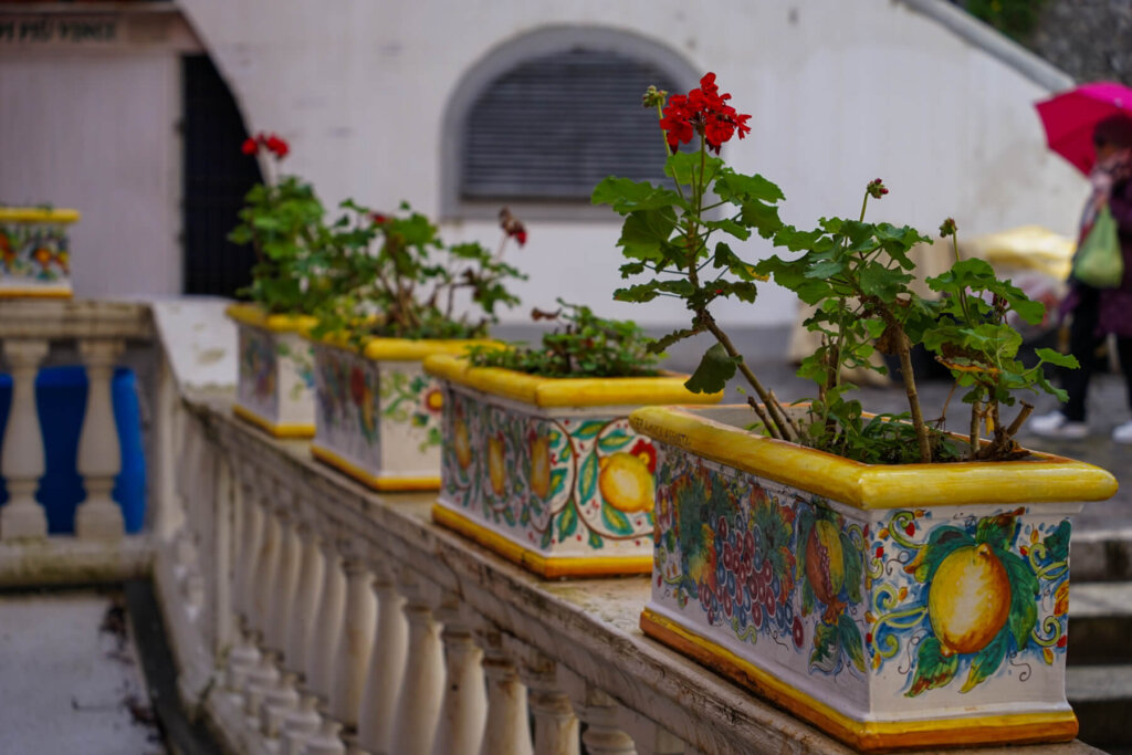 A drizzly day in Positano with a person with an umbrella in the background