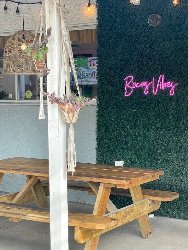 Bench and table with a sign that says Bocas Vibes