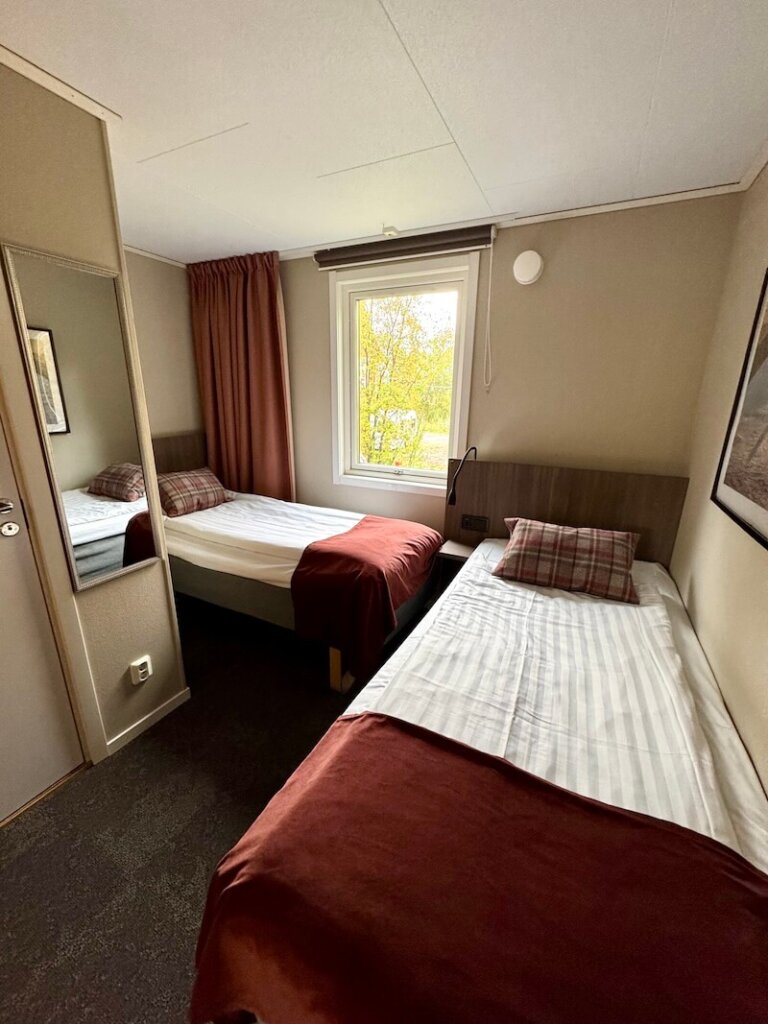 two twin beds in a small bedroom in an L-shape configuration