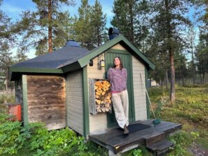 Allison Green standing in front of one of the cottages at Reindeer Lodge in Jukkasjarvi Sweden