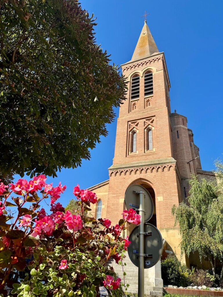 Church in the heart of town in Samatan France in a slightly red colored rock building