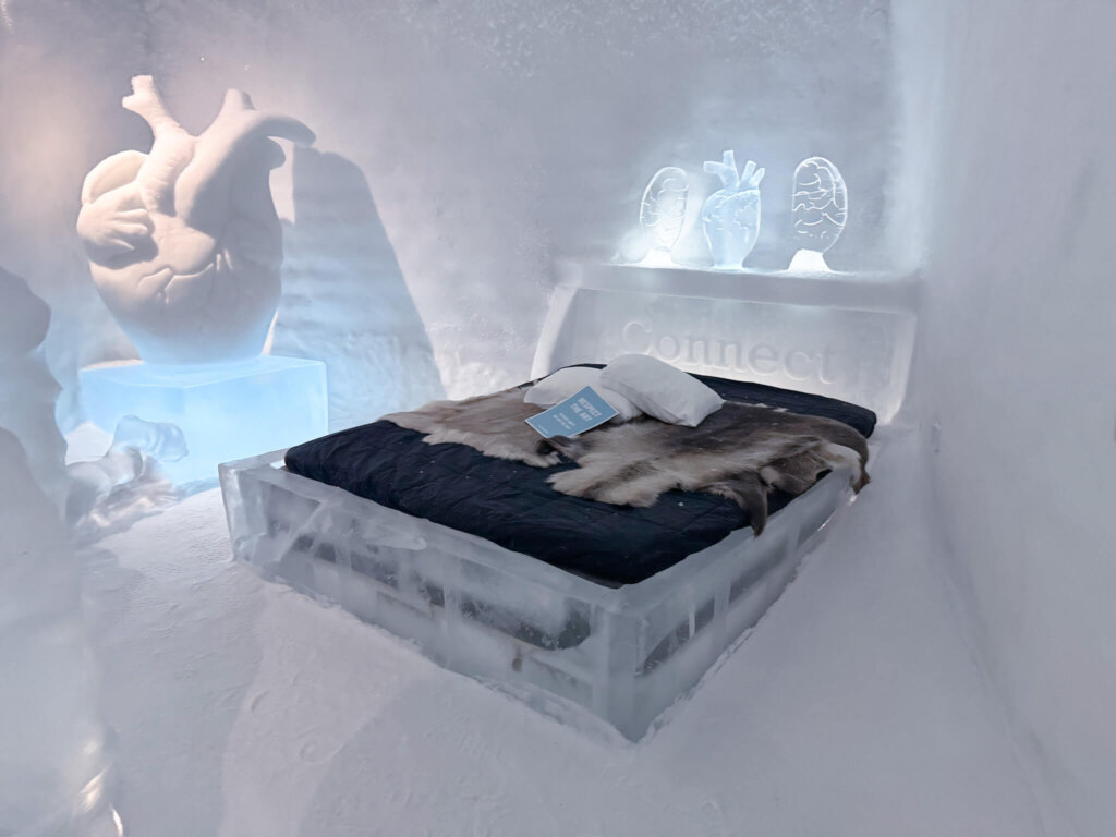 Ice hotel bed in Sweden at the Icehotel 365 with reindeer pelt bed