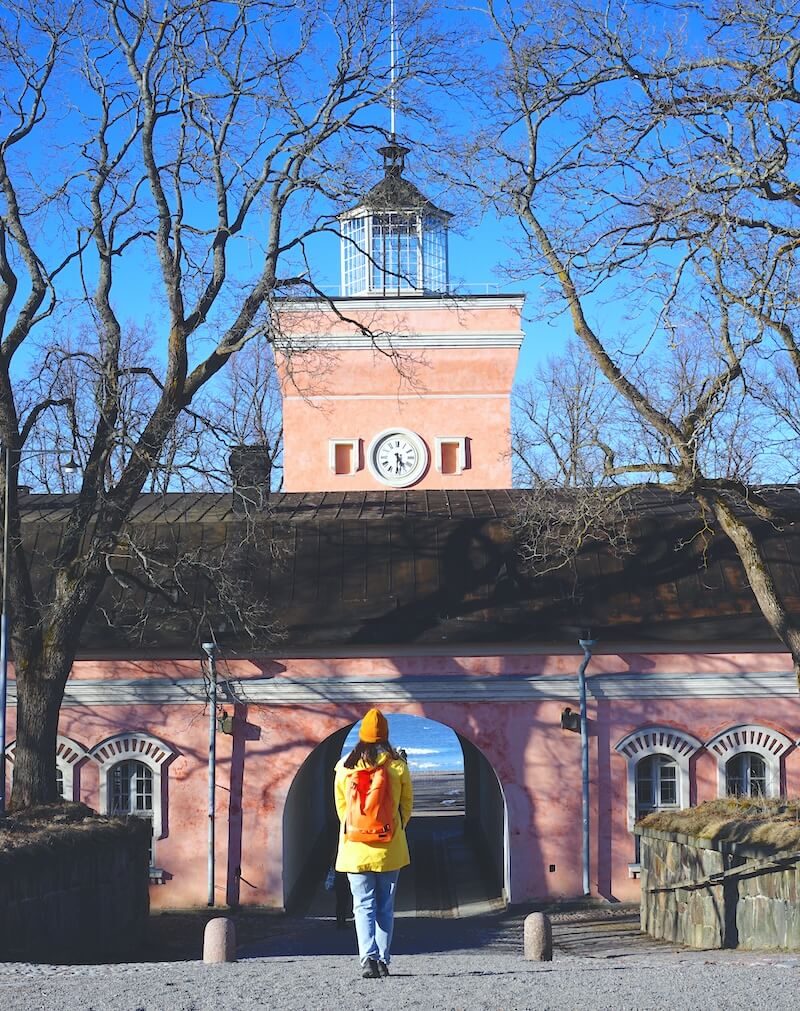 Allison Green, author of the article, walking away from the camera and towards the pink gate that is the entryway to Suomenlinna