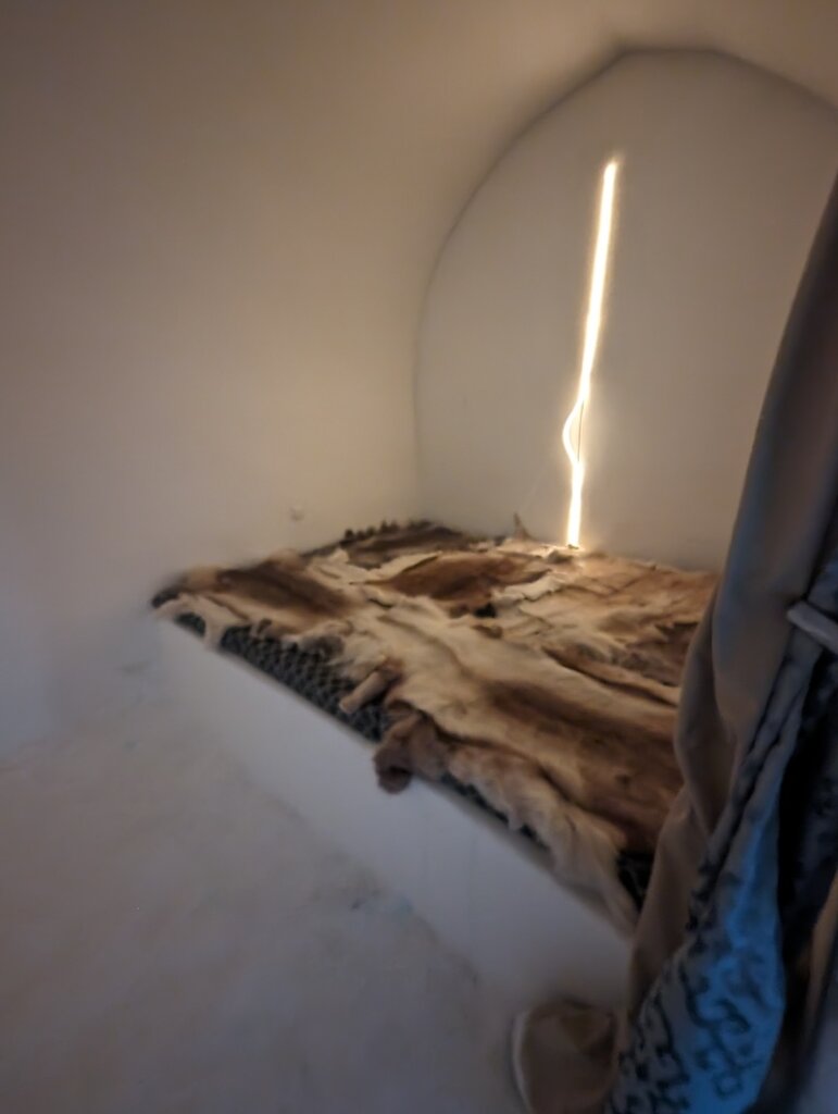 Reindeer pelts on a bed in a small room