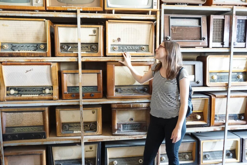 Allison looking lovingly at a bunch of old radios