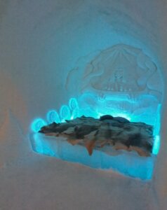 Blue toned lighting in a room with reindeer pelts and snow bed