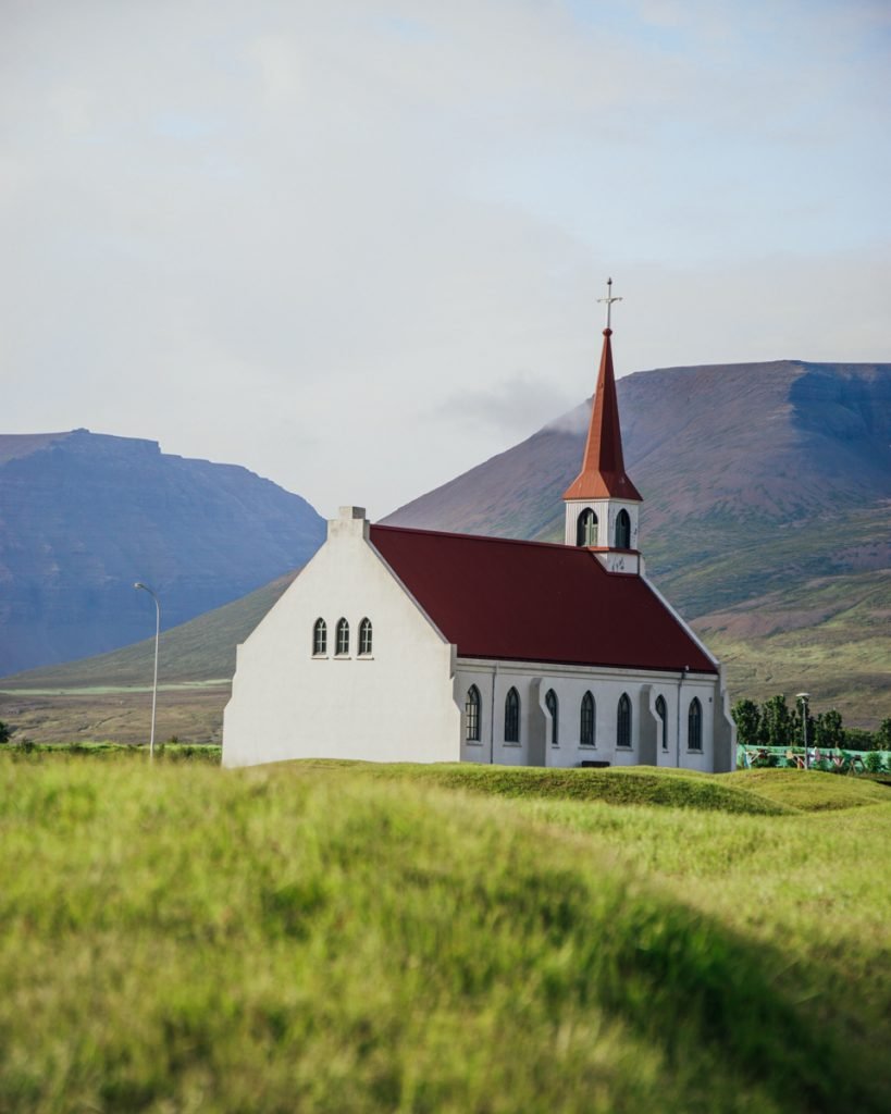 The famous church of Þingeyri with its red roof and mountain landscape