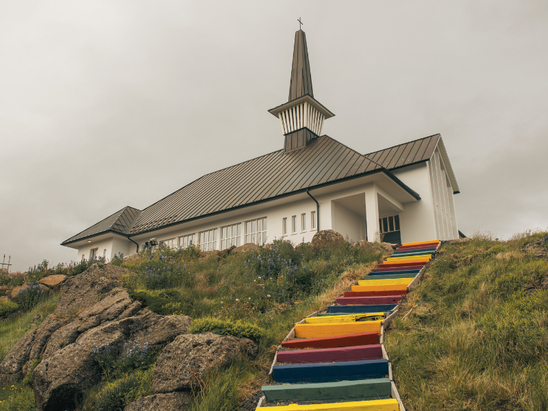 The rainbow steps in front of a church in Holmavik