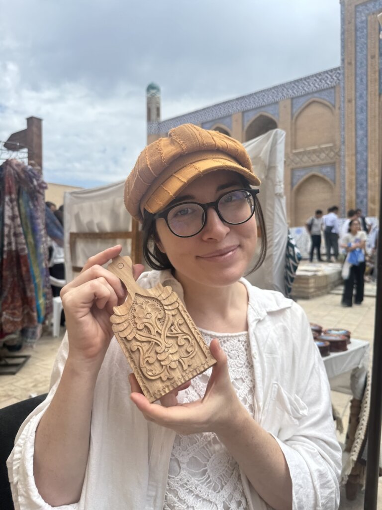 Allison Green holding the mini cutting board she created during her woodworking class in Khiva
