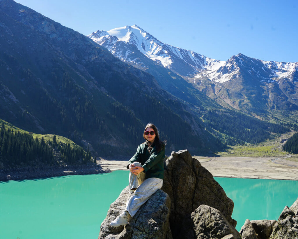 Allison Green sitting at Big Almaty Lake, part of the tour that includes Alma Arasan
