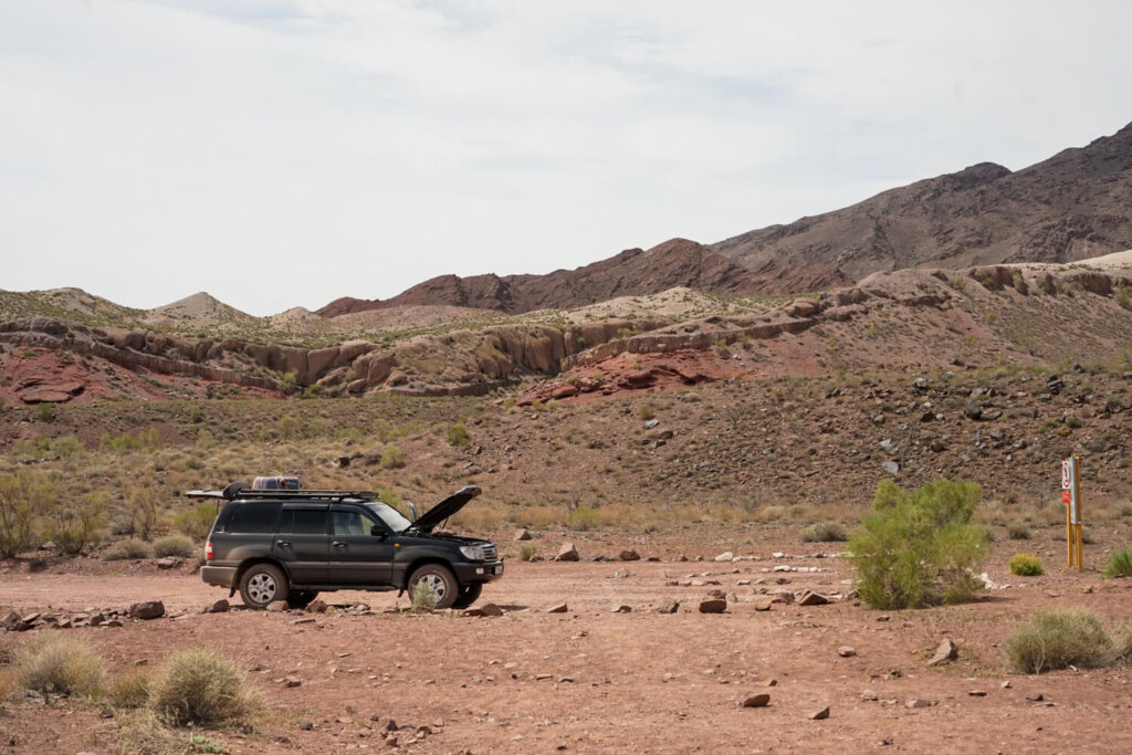Jeep with the hood up to cool down in the middle of a desert landscape