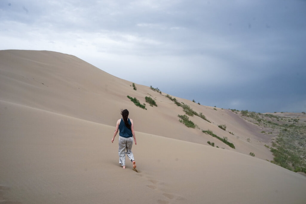 Allison Green walking away in the distance in the sand