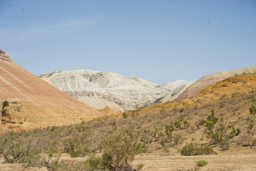 White chalk mountains in the distance with orange hills in the foreground
