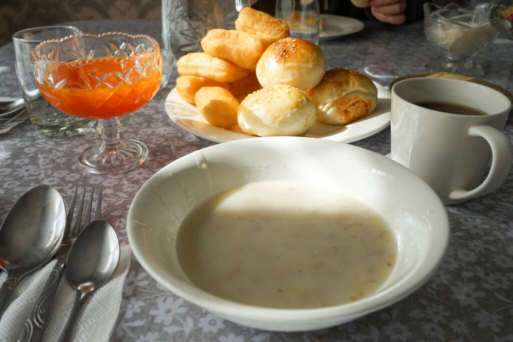 Breakfast with porridge, coffee, jam, and bread