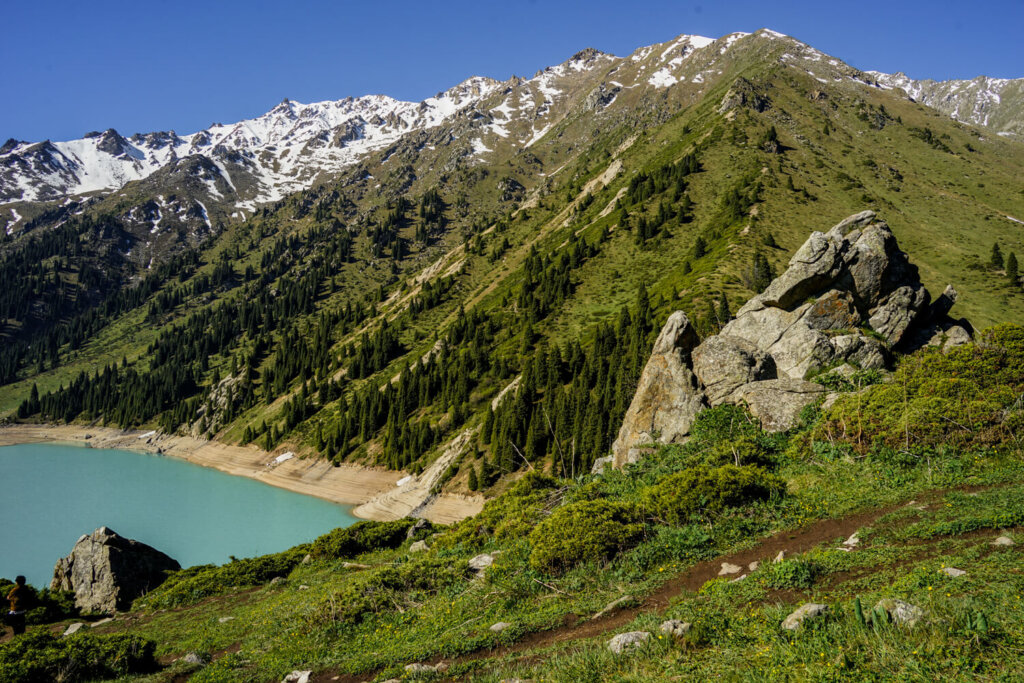 Views of the lake's edge and mountains and snow on the tops