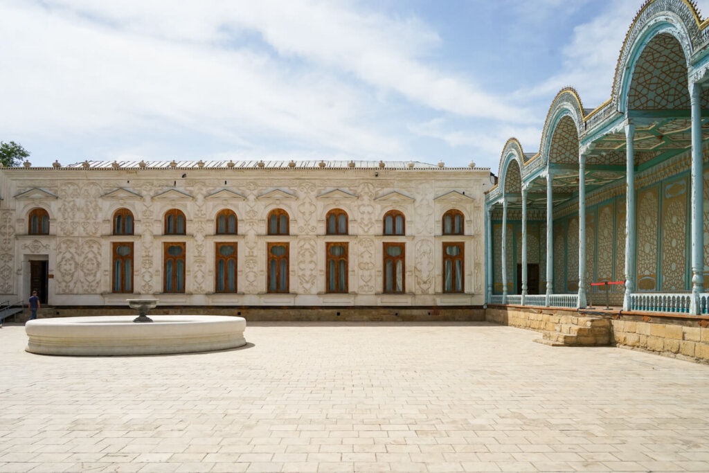 L shaped building of the summer palace main building with teal awning area next to the white palace