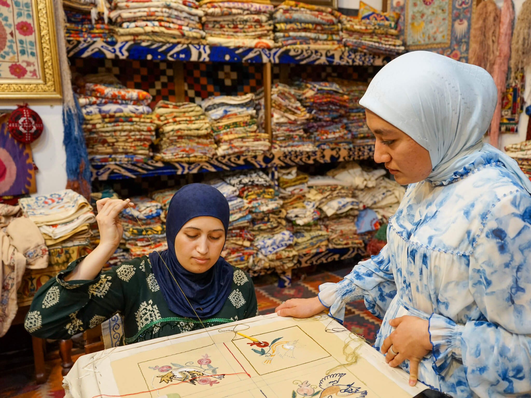 Two women, the guide and the master artisan, at a suzani embroidery class