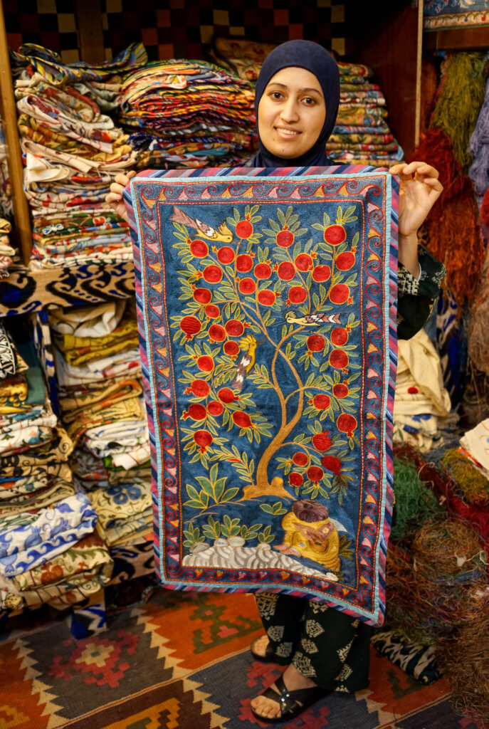 Suzani master teacher showing a piece of her work