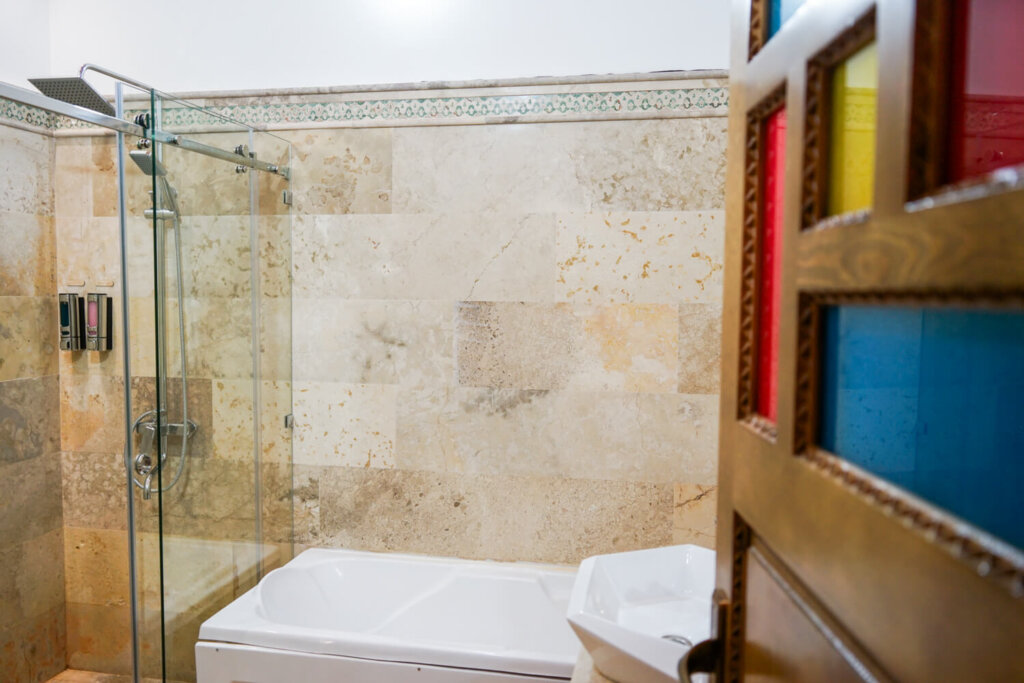 Bathroom with stained glass door, shower, and bathtub