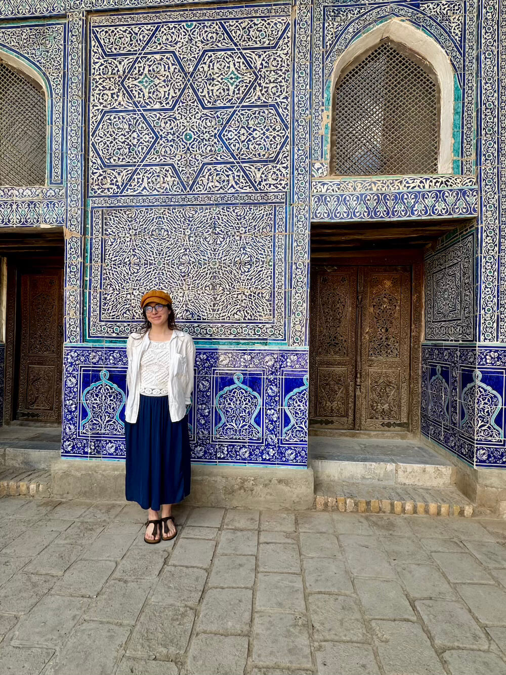 Allison wearing respectful clothing in Khiva: white jacket, white shirt, blue pants, sandals, hat