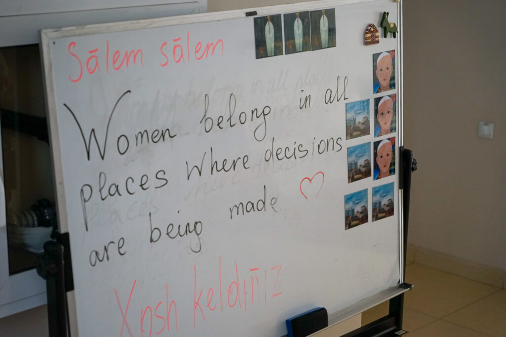 Sign that reads "women belong in all places where decisions are being made"