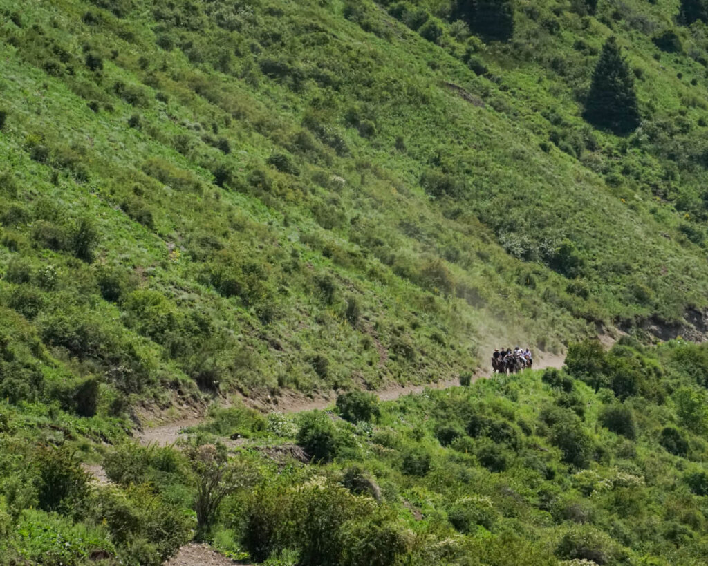 People on the horseback trail route up to Lake Kaindy